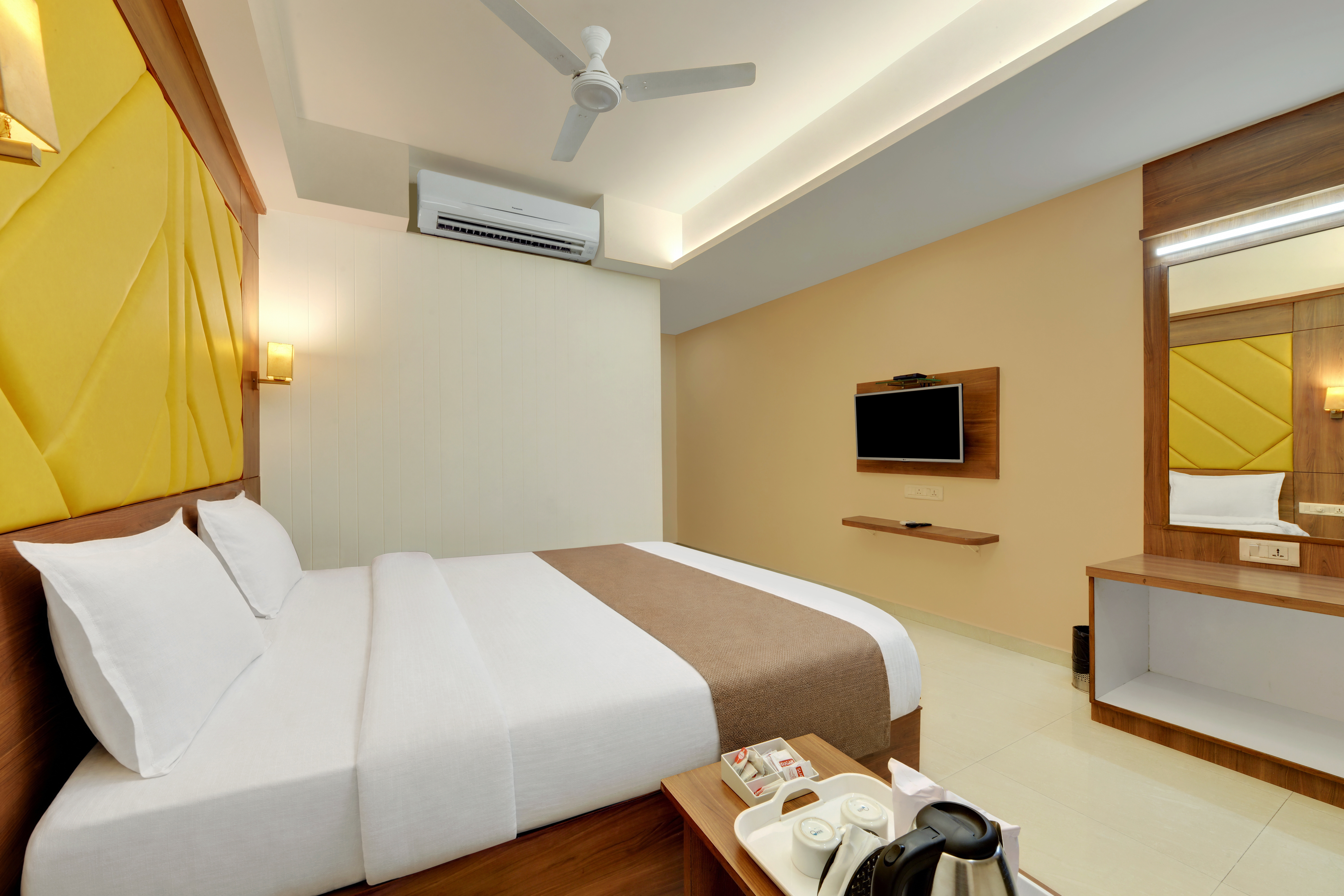 Hotel Shital Inn Deluxe Double Bed Room with upholstered headboard and television